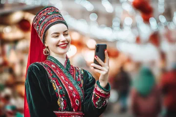 A man celebrating a winning moment on his laptop while gaming symbols float around him, capturing the excitement of 777ZK games.