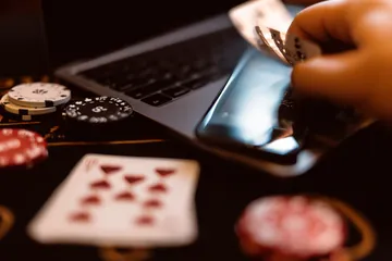 A woman smiling by bright slot machines showing lucky symbols, showcasing the exciting slot offerings at 777ZK.